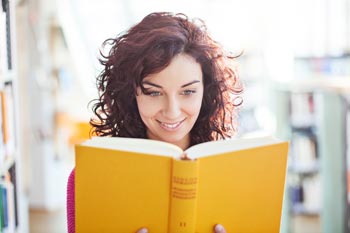 junge Frau guckt in Buch